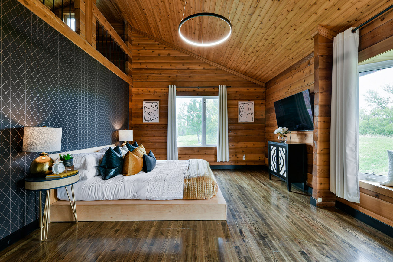 master bedroom with high ceiling and black accent wall